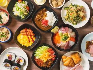 a table with many plates of food on it at The BREAKFAST HOTEL PORTO Ishigakijima in Ishigaki Island