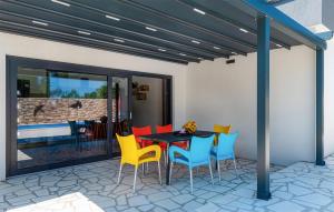 a patio with a black table and colorful chairs at Nice Home In Trbounje With Wifi in Trbounje