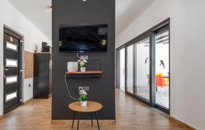 a living room with a table and a tv on a wall at Nice Home In Trbounje With Wifi in Trbounje
