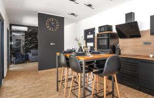 a kitchen with a table with chairs and a clock on the wall at Nice Home In Trbounje With Wifi in Trbounje