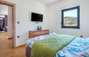a bedroom with a bed and a flat screen tv at Nice Home In Trbounje With Wifi in Trbounje