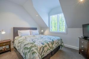 a bedroom with a bed and a tv and a window at Butterfly Cottage 2 or 3 Bedroom- Russell Cottages Collection in Russell