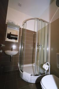 a bathroom with a shower and a toilet and a sink at Riva Rooms in Rijeka