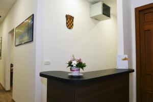 Una habitación con una mesa con un jarrón de flores. en Riva Rooms, en Rijeka