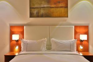 Un pat sau paturi într-o cameră la Roof Hotel Apartments