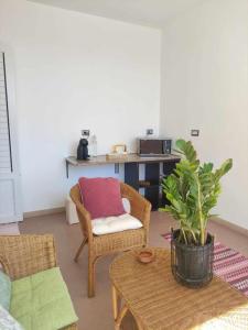 Una sala de estar con una silla y una mesa. en BB Guest House Ogliastra, en Tortolì