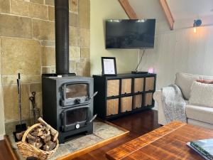 a living room with a wood stove in a room at The Loft at Shelford in Doroq