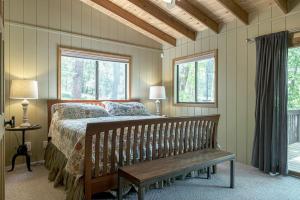 una camera con letto e panca in legno di Tarnhouse Lakefront Cottage a Innsbrook
