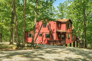 una casa rossa in mezzo alla foresta di Tarnhouse Lakefront Cottage a Innsbrook