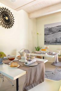 ein Esszimmer mit Tischen, Stühlen und einem Gemälde in der Unterkunft Resort Il Gallo Senone in Senigallia