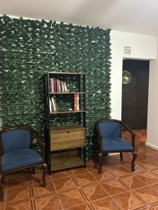 due sedie e una libreria davanti a un muro di "El Pelícano" Hostal a Maldonado Altre 21 foto