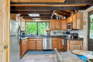 a kitchen with wooden cabinets and a stainless steel refrigerator at Lakefront A-Frame with Private Dock in Innsbrook