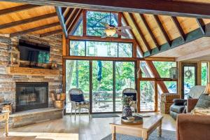 a living room with a fireplace and a stone wall at Lakefront A-Frame with Private Dock in Innsbrook