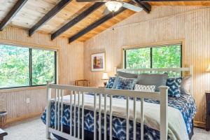 a bedroom with a bed in a room with windows at Lakefront A-Frame with Private Dock in Innsbrook
