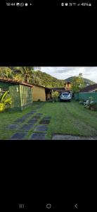 a car parked in a yard next to a house at Recanto Sertão do Camburi in São Sebastião
