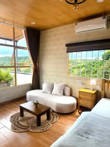 a bedroom with two beds and a coffee table in it at Dứa Homestay in Bảo Lộc