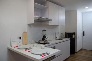 a kitchen with white cabinets and white plates on a counter at Apartamento en el centro Bogotá in Bogotá