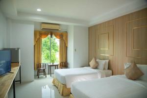 a hotel room with two beds and a television at Gassan Panorama Golf Club in Ban San Pa Hiang
