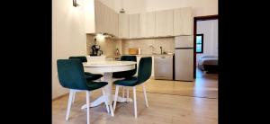 a kitchen with a white table and green chairs at Apartment Bregava in Stolac