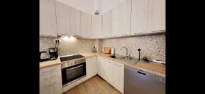 a kitchen with white cabinets and stainless steel appliances at Apartment Bregava in Stolac