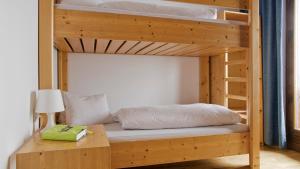 a bedroom with two bunk beds with a table and a lamp at Appartements Kühtai in Kühtai