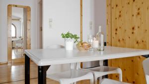 Una mesa blanca en una cocina con sillas blancas. en Appartements Kühtai, en Kühtai