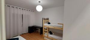 a bedroom with a bunk bed and a white wall at Sapucaia Flat - Apart Hotel in Santa Rita do Sapucaí +2 photos