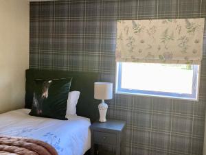una camera con letto, finestra e lampada di Willow Tree Cottage a Lincoln