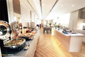 a kitchen with a buffet of food on a counter at Calligraphy Greenway Hotel in Taichung