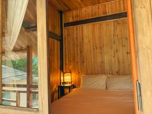 a bed in a wooden room with a window at Sapa Tranquilla in Sa Pa