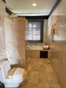a bathroom with a toilet and a sink and a tub at Gassan Legacy Golf Club in Lamphun