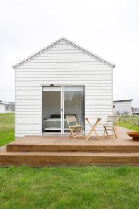 CollectorMurray Tiny Home Collector的大楼前的木甲板上摆放了两把椅子