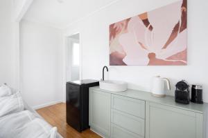 CollectorMurray Tiny Home Collector的白色的浴室设有水槽和一张床 更多7张照片
