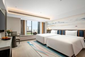 Rúm í herbergi á Mehood Lestie Hotel Maoming High-speed Railway