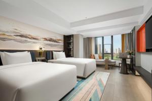 Rúm í herbergi á Mehood Lestie Hotel Maoming High-speed Railway