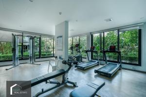 - une salle de sport avec 3 tapis de course et des fenêtres dans l'établissement Cozy Studio Apartment at Naiyang Beach G507, à Phuket