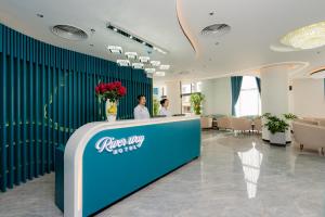Dos personas de pie en un mostrador en un vestíbulo. en River Way Hotel Ha Long, en Ha Long 20 fotos más