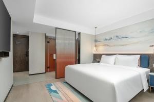 Rúm í herbergi á Mehood Lestie Hotel Maoming High-speed Railway