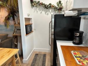 a kitchen with a black refrigerator and a table at Studio Apartment 5 minutes from beach in St Petersburg +2 photos