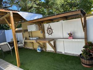 a wooden pergola with a table and a bench at Studio Apartment 5 minutes from beach in St Petersburg