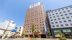 un edificio alto en medio de una ciudad en Toyoko Inn Tokushima eki Bizan guchi, en Tokushima