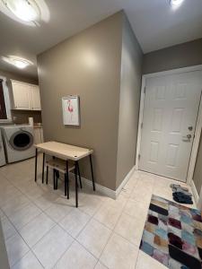 a kitchen with a table and a door in a room at Zp Home Richmond Cozy Garden Suite Near YVR in Richmond