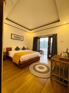 a bedroom with a bed and a television and a table at Volcano Vista Inn in Kubupenlokan