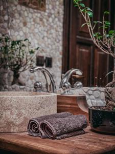 a bathroom counter with a sink and a rolled up towel at Rönkház Noszvaj in Noszvaj