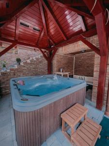a large hot tub in a building with a bench at Rönkház Noszvaj in Noszvaj