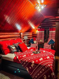 a bedroom with a large bed with red pillows at Rönkház Noszvaj in Noszvaj