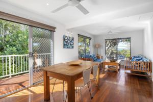 a dining room with a wooden table and chairs at 47 Plover Street Peregian Beach in Peregian Beach