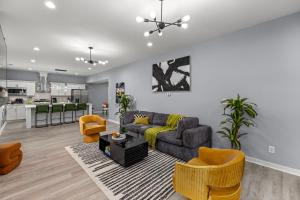 a living room with a couch and chairs and a kitchen at Central Indy 5BD - Pingpong - Outdoor Movie - BBQ in Indianapolis