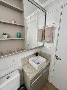 a bathroom with a sink and a mirror at Lindo apartamento no centro de Canoas in Canoas