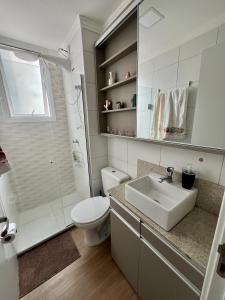 a white bathroom with a sink and a toilet at Lindo apartamento no centro de Canoas in Canoas +6 photos